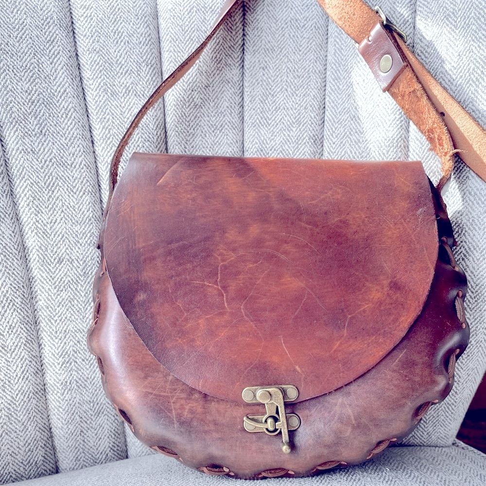100% natural leather satchel with metal hardware closure.  Gorgeous!